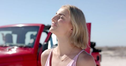 Young Woman Enjoying Sunshine on Road Trip Outdoors