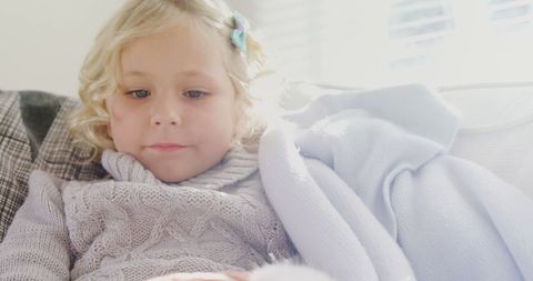 Serene child relaxing in cozy blanket bright setting