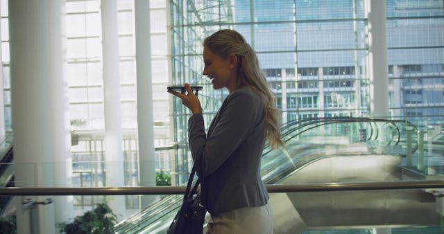 Businesswoman Talking on Phone in Modern Office Atrium - Download Free Stock Images Pikwizard.com