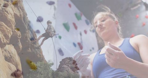 Woman chalks hands for rock climbing adventure