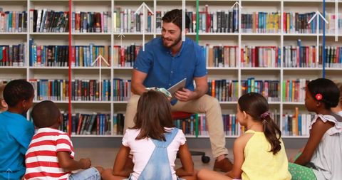 Brother reading to attentive children in library setting