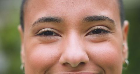 Close-Up Portrait of Smiling Woman Radiating Joy in Bright Outdoor Setting