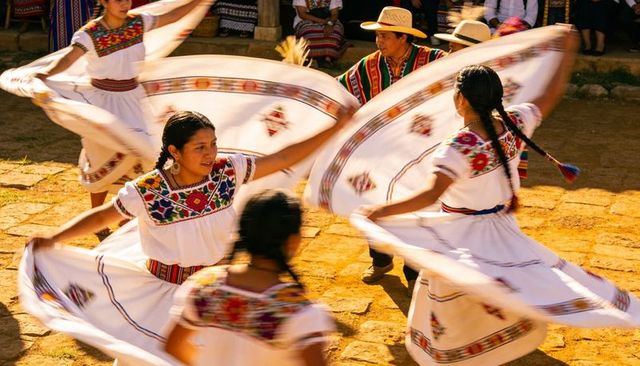 Vibrant mexican folk dance twirling huipil skirts sunlit courtyard motion and textiles