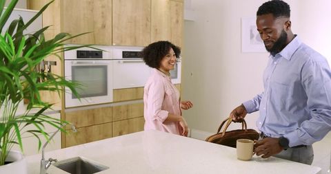 Smart-casual couple preparing morning in modern kitchen with quartz island