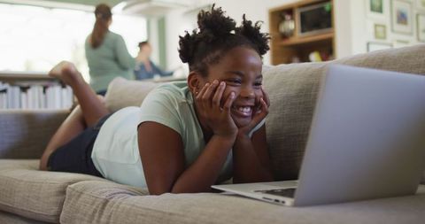 Joyful African American Girl Enjoying Laptop Time on Sofa