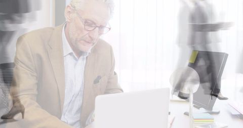 Businessman Focused on Laptop Amid Moving Commuters