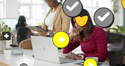 Professional woman working on laptop with collaboration icons overlay in modern office