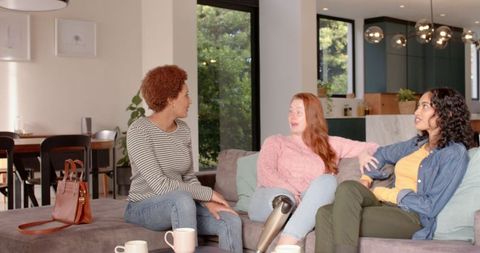 Diverse female friends relaxing with coffee at home