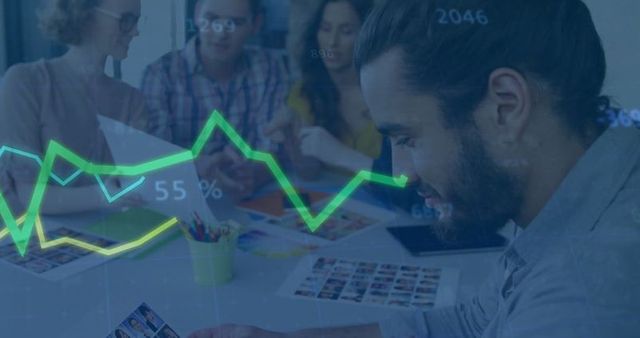 Bearded man analyzing data with team at creative workspace