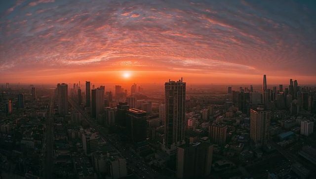 City skyline glowing at sunset with dramatic cloudscape and urban panorama from above