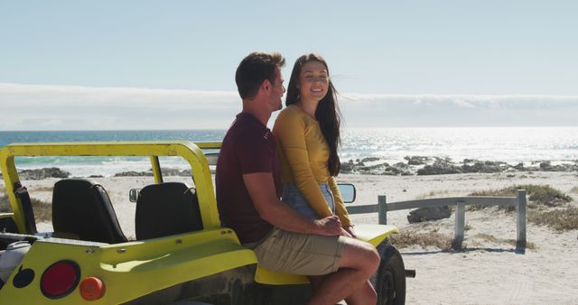 Couple sitting on yellow buggy looking at scenic beach. Ideal for travel ads, vacation promotions, summer campaigns, or lifestyle blogs focusing on seaside leisure and romantic getaways.