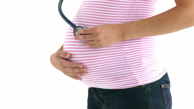 Close-up captures pregnant woman holding a stethoscope to her bare belly, listening to fetal heartbeat. Ideal for use in articles about pregnancy, prenatal care, maternity health, and expectant mothers. Suitable for health and wellness blogs, medical guides, and pregnancy-related educational materials.