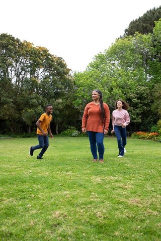 Diverse Family Playing on Green Lawn in Sunlit Park