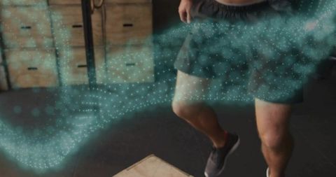 Male athlete stepping onto plyo box with teal particle motion for explosive training