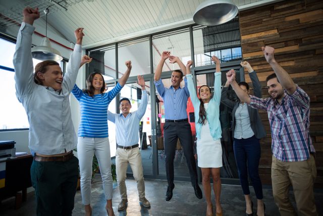 Team of excited businesspeople jumping in office