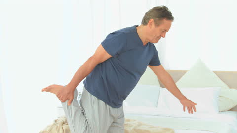 Retired Man Stretching in Bedroom Morning Routine