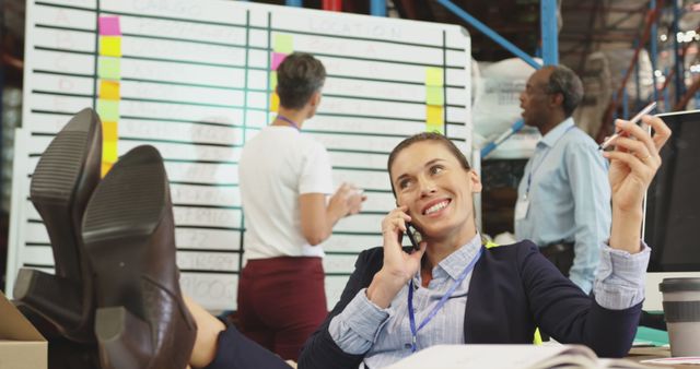 Confident Businesswoman Relaxing While Having Phone Call in Busy Office - Download Free Stock Images Pikwizard.com