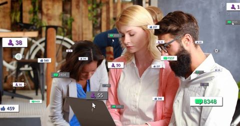 Team collaborating over laptop with floating social media analytics widgets in coworking lounge