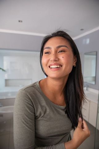 Elegant Asian Woman Standing in Modern Bathroom