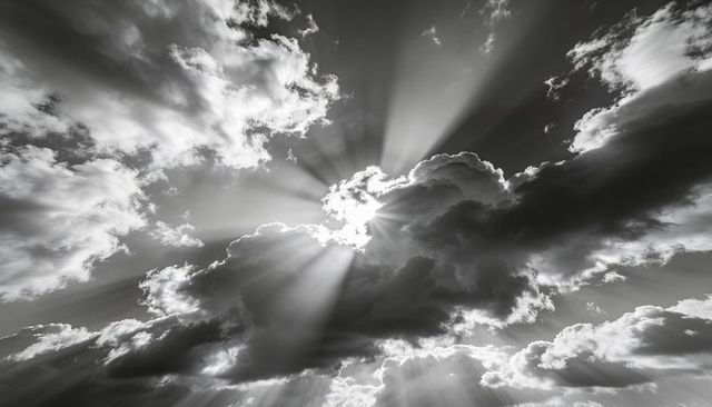 Dramatic black and white sky with sunbeams piercing rim-lit storm clouds, crepuscular rays
