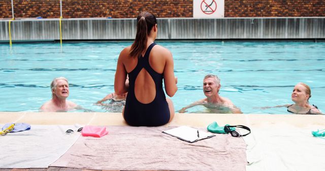 Swim Instructor Teaching Senior Swimmers Poolside in Indoor Facility - Download Free Stock Images Pikwizard.com