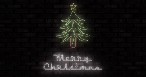 Neon christmas tree sign glowing on brick wall casting merry christmas script glow