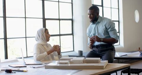 Business Colleagues Engaging in Office Meeting with Architectural Plans