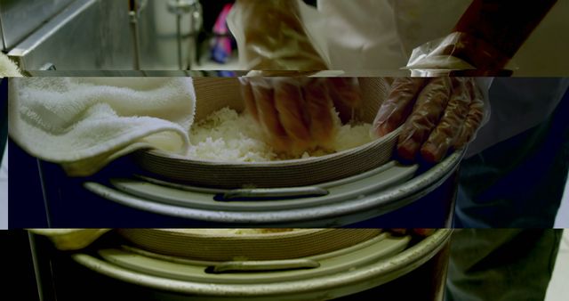 Chef is preparing fresh sushi rice in a restaurant kitchen, highlighting the meticulous process and maintaining hygiene by using gloves. Ideal for illustrating culinary practices, food preparation techniques, and Japanese cuisine. Suitable for blogs, articles, and websites focusing on cooking, professional kitchens, and restaurant operations.