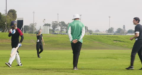 Cricket Players Practicing on Field in Morning Light