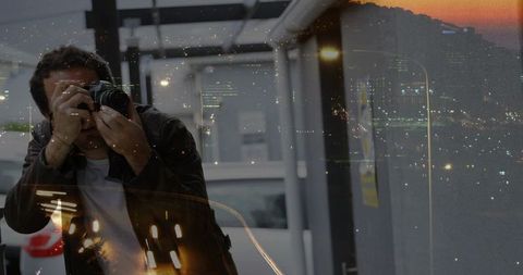 Photographer with dslr capturing night skyline reflections