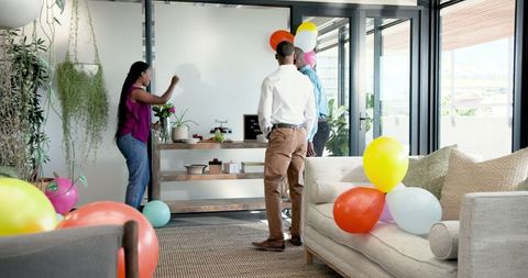 Colleagues decorating modern office for celebration