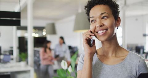 Professional Businesswoman Smiling on Phone in Modern Office