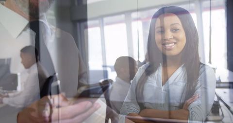 Confident Businesswoman Overlooking Busy Office Environment