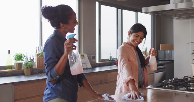 Image of happy diverse female friends cleaning house and dancing. Friendship, spending quality time together at home.