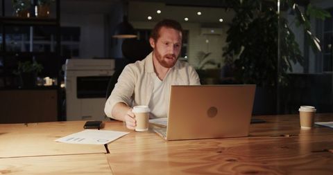 Nighttime Office Meeting with Laptop Discussion