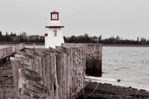 Rustic Seaside Landscape with White Lighthouse in Background
