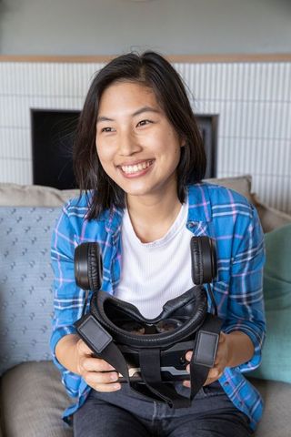 Smiling Woman Relaxing at Home with Virtual Reality Headset