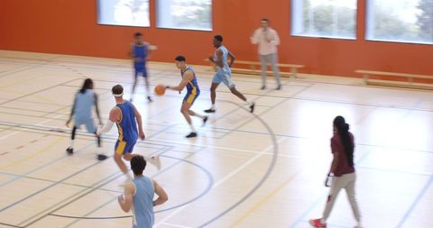Dynamic Indoor Basketball Game with Focused Male Athlete