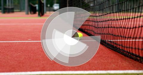 Tennis ball against net on red clay court