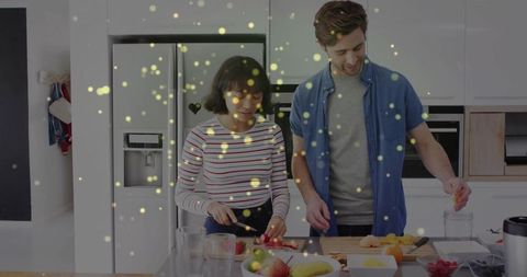 Couple chopping fruits together in modern kitchen