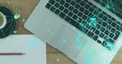 Digital Icons Overlay Laptop on Wooden Desk