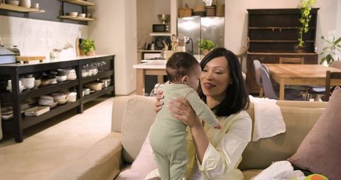 Mother Bonding With Child on Sofa in Modern Open-Plan Kitchen