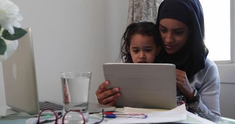 Mother in Hijab Teaching Her Daughter with Tablet