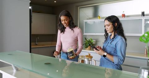 Women Preparing Drink Together in Modern Kitchen