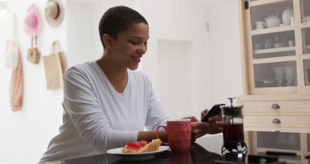 Smiling African American Woman Using Smartphone in Modern Kitchen - Download Free Stock Images Pikwizard.com