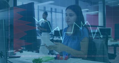 Businesswoman reviewing data with financial dashboard overlay in collaborative open office