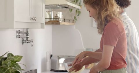 Diverse couple mixing ingredients in cozy kitchen environment