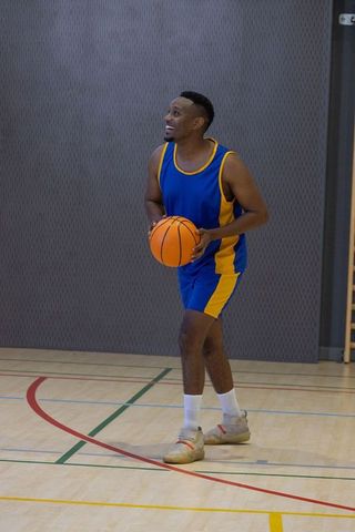 Energetic Basketball Player Preparing to Shoot Hoop in Indoor Court