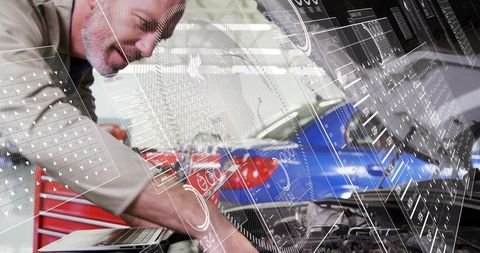 Senior technician performing augmented reality diagnostic scan on car engine with laptop