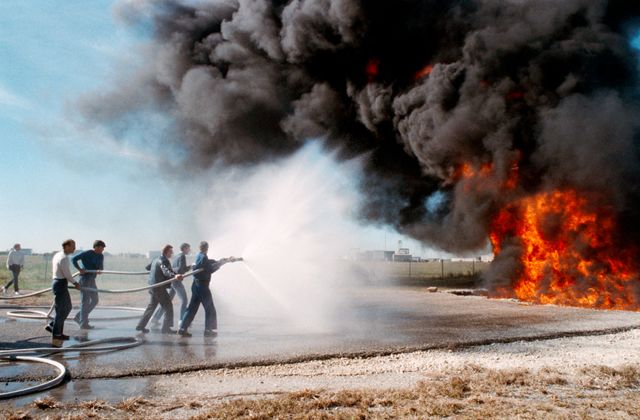 S88-54945 (6 Dec 1988) --- The STS-29 crewmembers are trained in procedures to follow in the event of a fire with their spacecraft.  Here, Astronauts Michael L. Coats (far left), mission commander, and James P. Bagian, mission specialist, follow the lead of two fellow crewmembers as they extinguish a fire. The astronauts in front of the action are Robert C. Springer, mission specialist, and John E. Blaha, pilot.  Not pictured is James F. Buchli, mission specialist. Their instructor, center, is Robert Fife of NASA's security staff. The training took place on the northern end of the 1625-acre JSC facility.